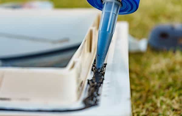 Applying Sealant on Metal Surface — Building Supplies in Heatherbrae, NSW