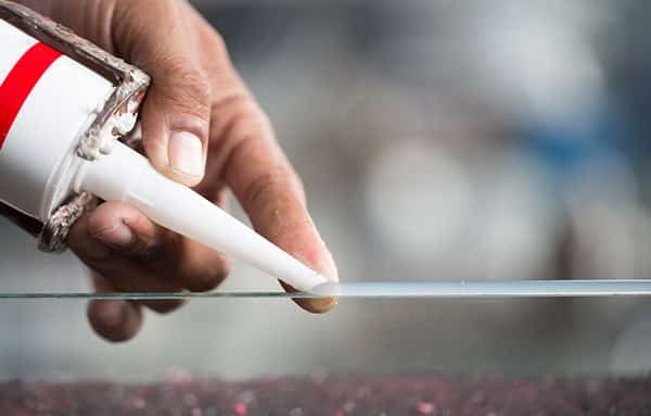 Applying Sealant on the Glass — Building Supplies in Heatherbrae, NSW