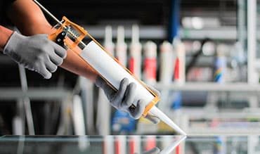 Man Holding A Sealant Tube — Building Supplies in Cessnock, NSW