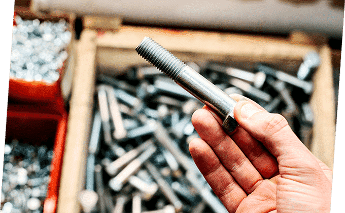 Man Holding Screw — Building Supplies in Heatherbrae, NSW