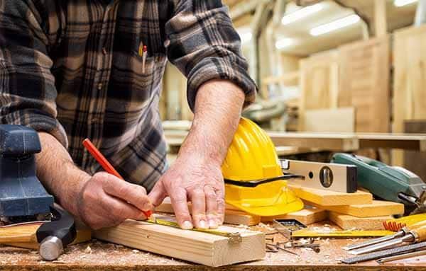 Man Measuring the Wood — Building Supplies in Heatherbrae, NSW