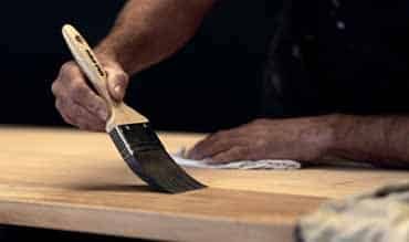 Man Applying Varnish to the Wood — Building Supplies in Heatherbrae, NSW