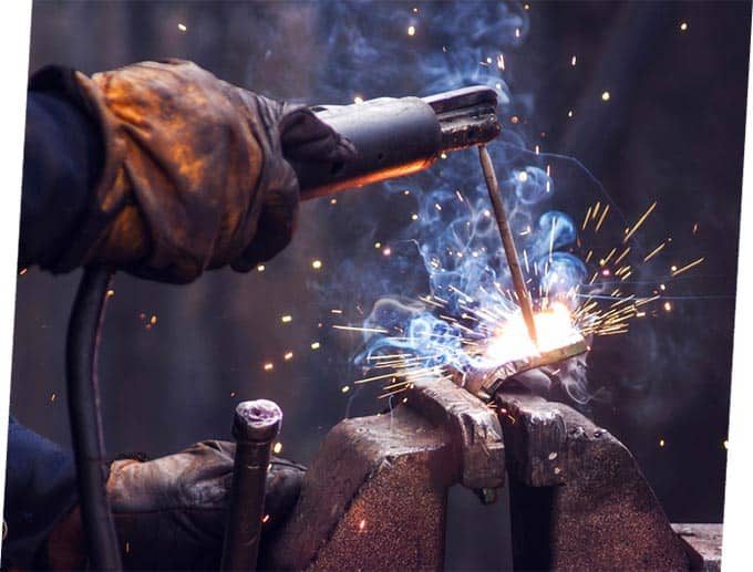 Worker Welding Iron Pieces — Building Supplies in Port Stephens, NSW